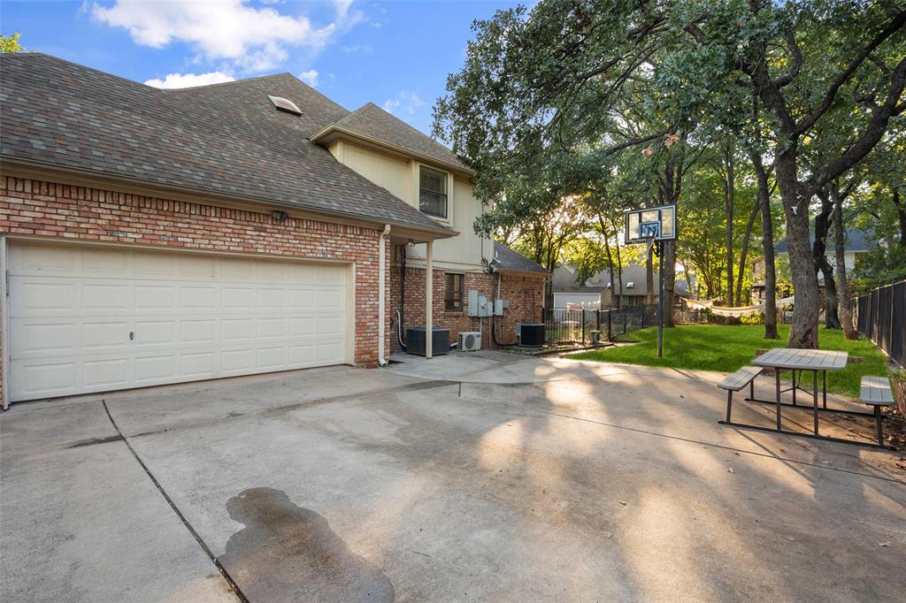 424 Windjammer Lane Azle, TX 76020 - Photo 33 of 37 View of side of home with brick siding, roof with shingles, a garage, and driveway