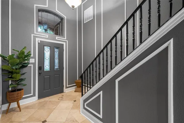 a view of staircase with lots of frames on wall and a potted plant