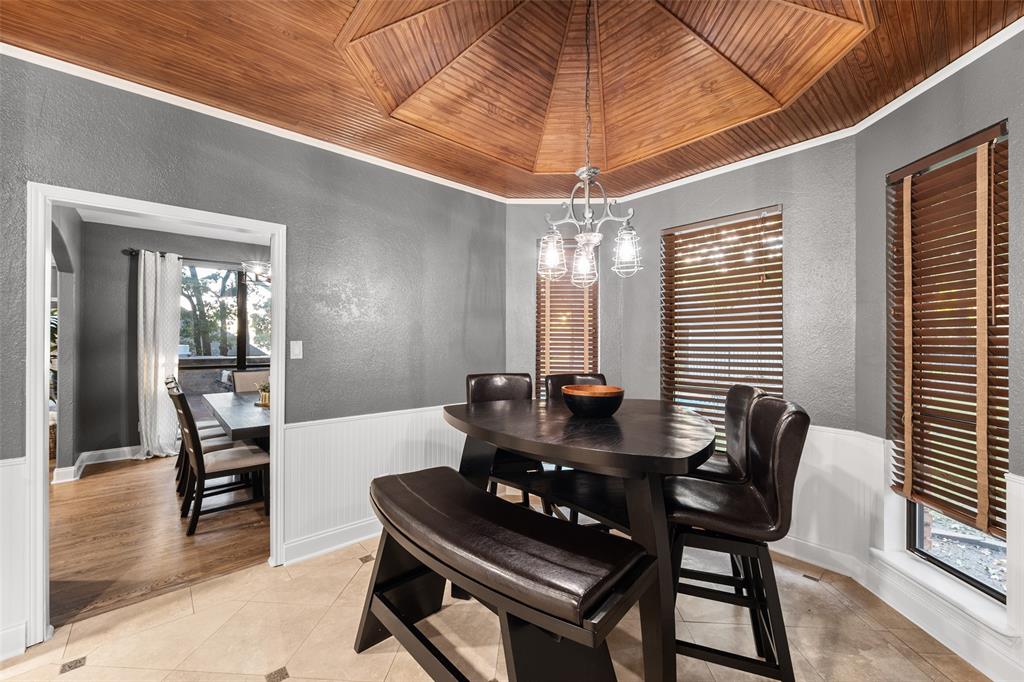 424 Windjammer Lane Azle, TX 76020 - Photo 7 of 37 Dining space featuring a textured wall, wooden ceiling, light tile patterned floors, wainscoting, and crown molding