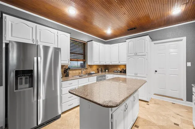 a kitchen with stainless steel appliances granite countertop a refrigerator a sink and a stove