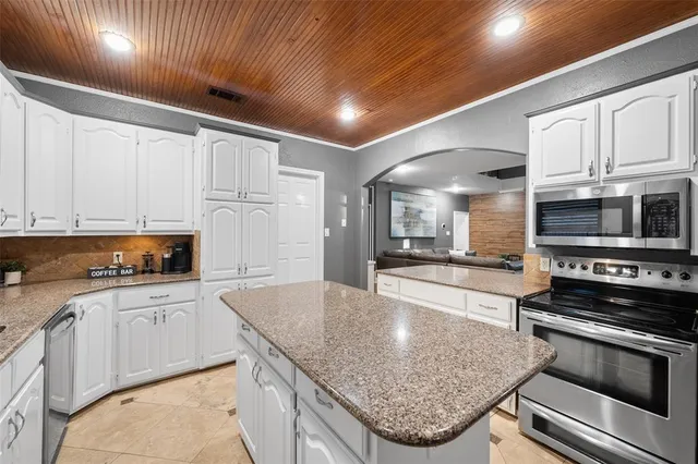 a kitchen with stainless steel appliances granite countertop a stove sink and cabinets