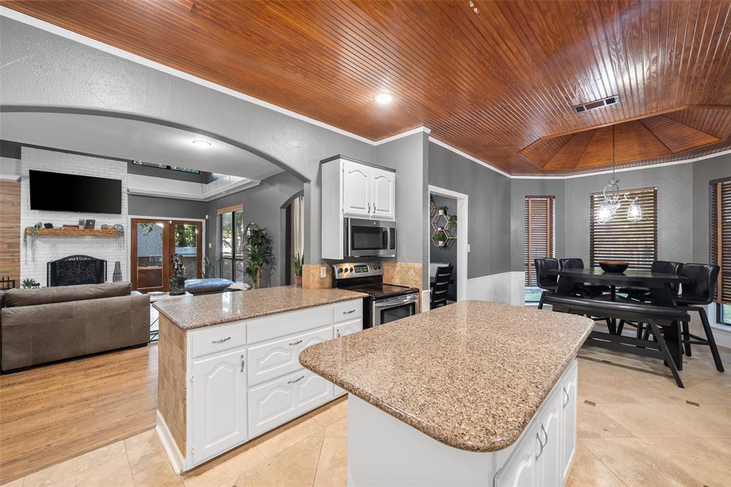 424 Windjammer Lane Azle, TX 76020 - Photo 36 of 37 Kitchen with open floor plan, a fireplace, arched walkways, wood ceiling, and appliances with stainless steel finishes