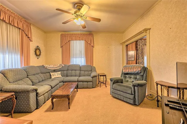 a living room with furniture a ceiling fan a fireplace and a window