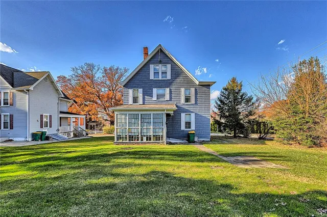 a front view of a house with a yard and trees