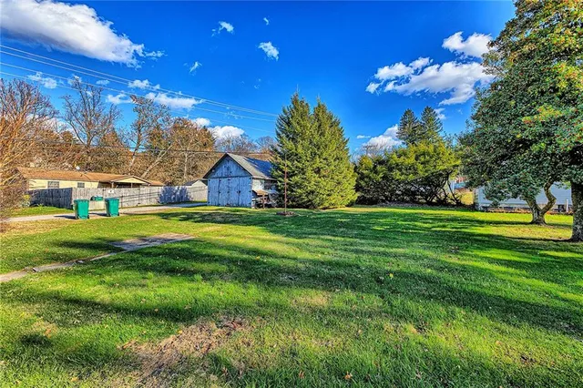 a view of yard with swimming pool and green space