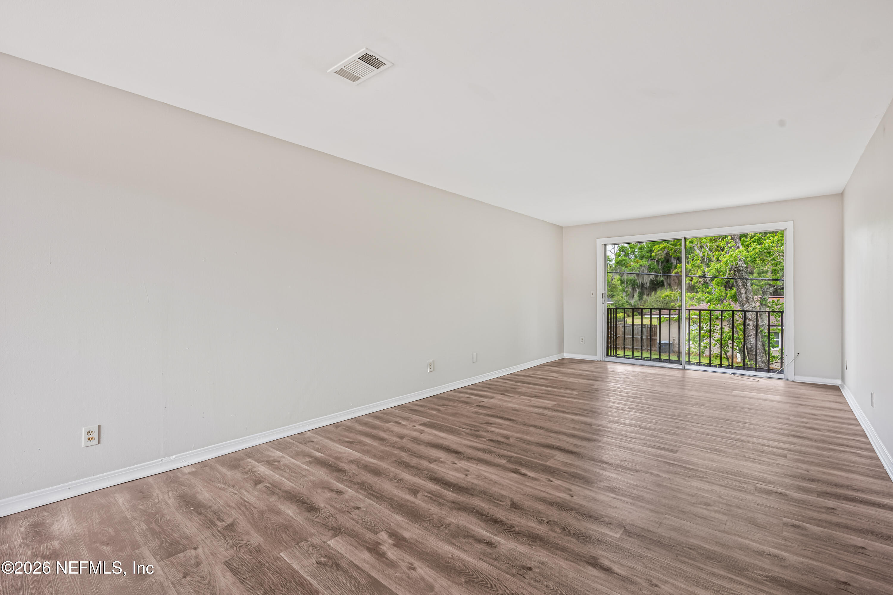 1716 El Camino Road, Unit 6 Jacksonville, FL 32216 - Photo 3 of 18 a view of an empty room with wooden floor and a window