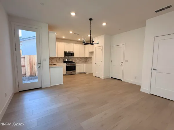 a view of a kitchen with a refrigerator wooden floor and a kitchen