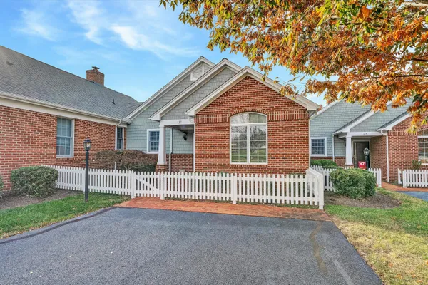 a view of a house with a small yard and a large tree