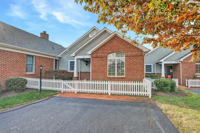 a view of a house with a small yard and a large tree