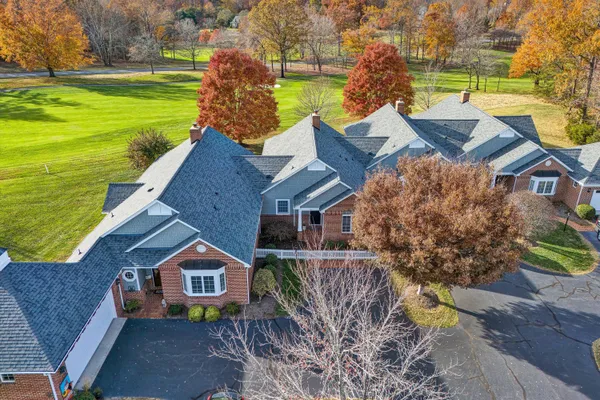 an aerial view of a house with a garden and lake view