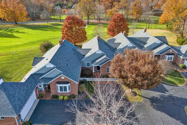 an aerial view of a house with a garden and lake view
