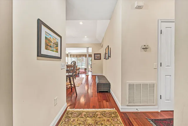 a view of a hallway with furniture and wooden floor