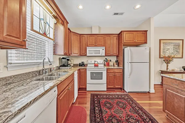 a kitchen with stainless steel appliances granite countertop a refrigerator sink and stove