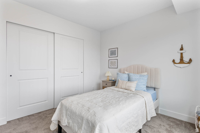636 West Caroles Way, Unit 7 Tooele, UT 84074 - Photo 18 of 31 Spacious bedroom featuring white walls, plush carpet flooring, and a large closet with paneled sliding doors