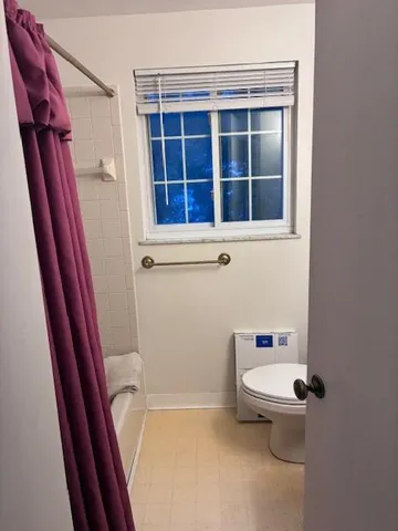 a bathroom with a toilet and a shower