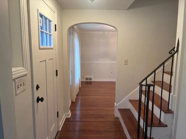 a view of a hallway with wooden floor and staircase