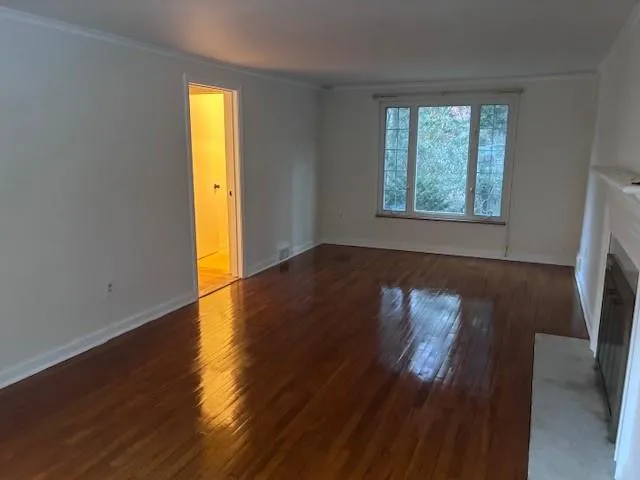 an empty room with wooden floor and a window