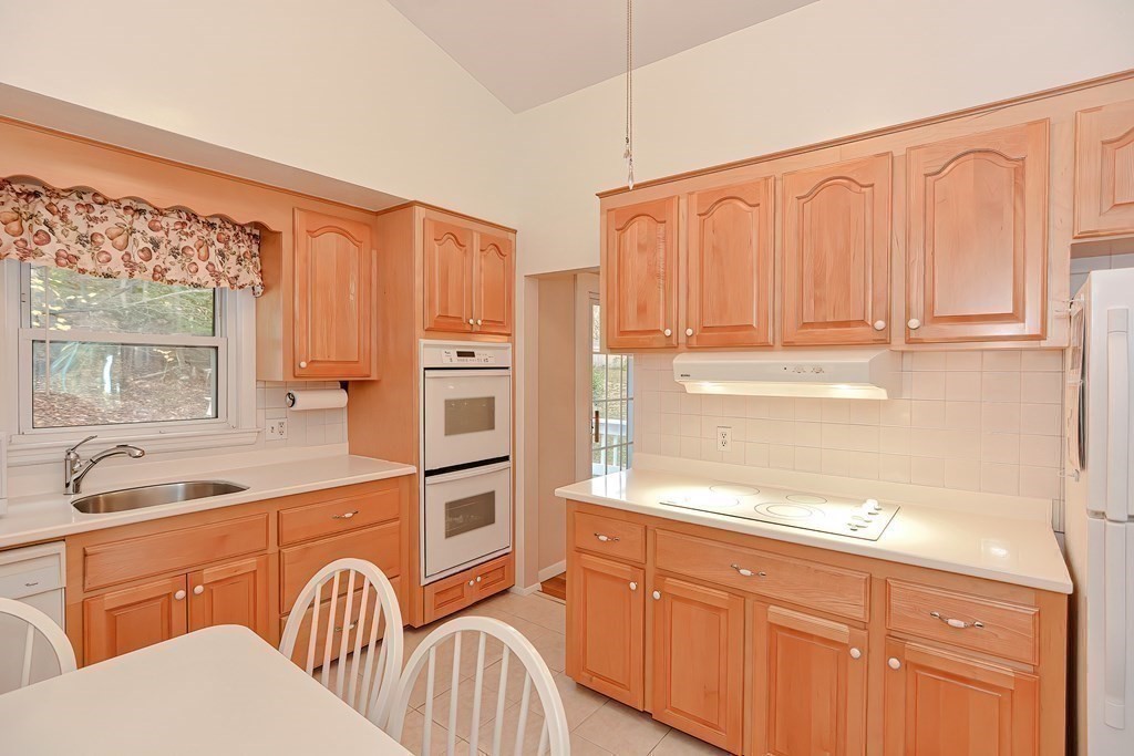 23 Edward Street Canton, MA 02021 - Photo 12 of 40 a kitchen with stainless steel appliances granite countertop a sink a stove a refrigerator with white cabinets and wooden floor