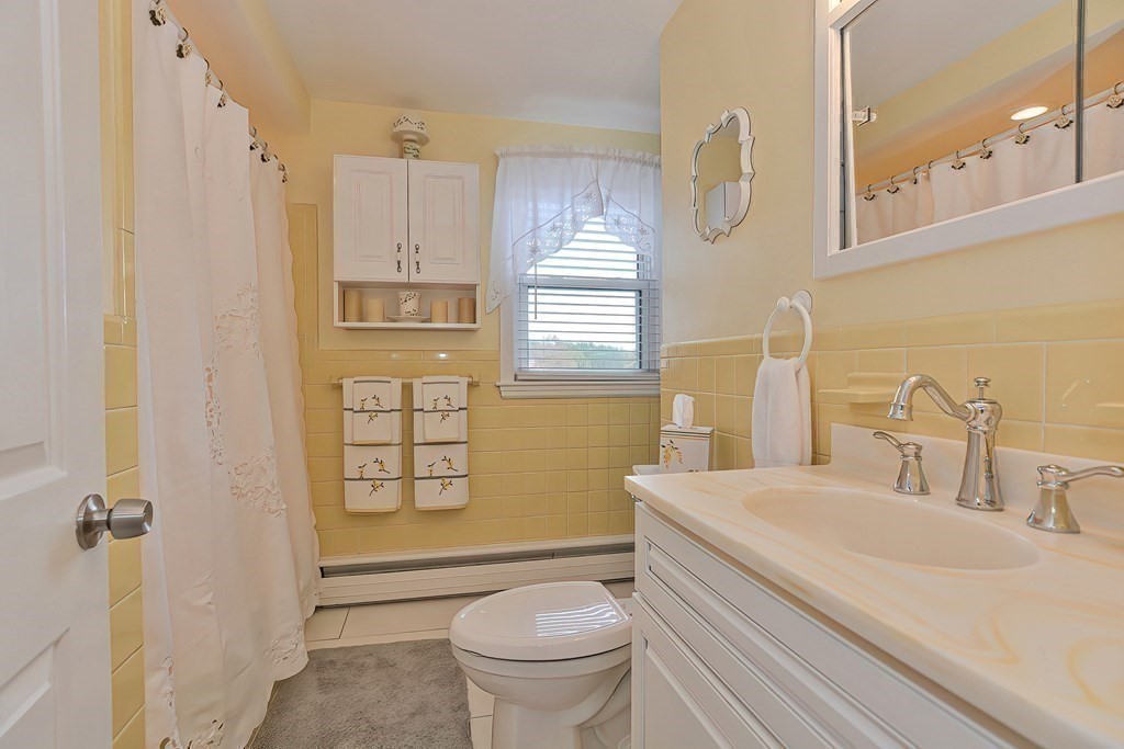 23 Edward Street Canton, MA 02021 - Photo 23 of 40 a bathroom with a sink a toilet and a large mirror