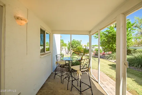 a view of a porch with dining table and chairs