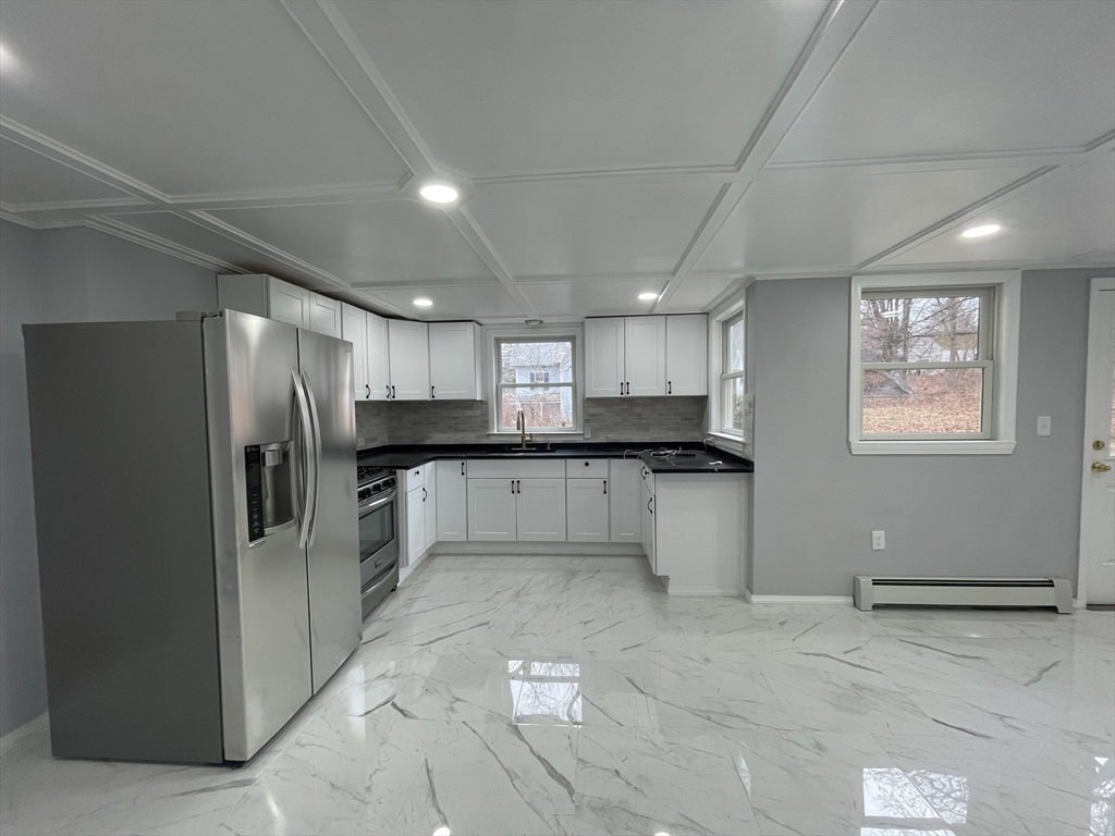 59 High Street Warren, MA 01083 - Photo 9 of 42 a large kitchen with a refrigerator and a stove top oven