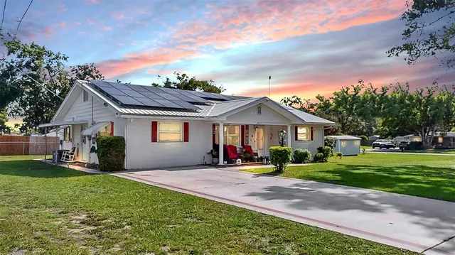 a front view of a house with a yard and trees