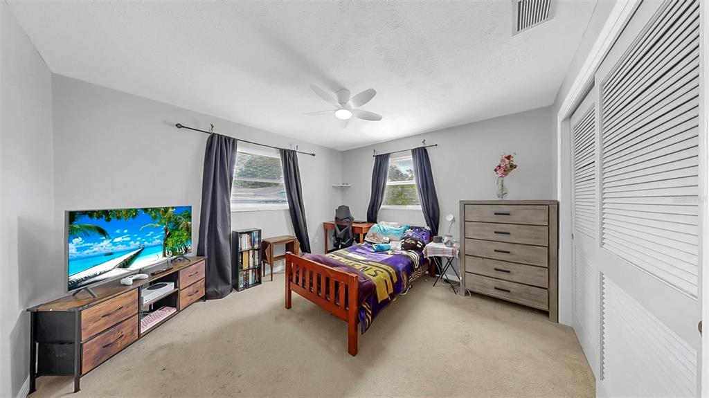 38919 3rd Avenue Zephyrhills, FL 33542 - Photo 15 of 36 a bedroom with furniture and a flat screen tv