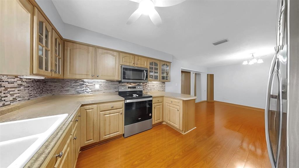38919 3rd Avenue Zephyrhills, FL 33542 - Photo 7 of 36 a kitchen with stainless steel appliances granite countertop a stove a sink and a refrigerator