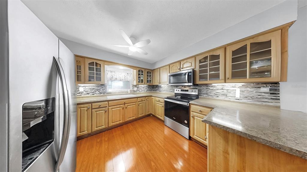 38919 3rd Avenue Zephyrhills, FL 33542 - Photo 9 of 36 a kitchen with stainless steel appliances granite countertop a stove sink and cabinets