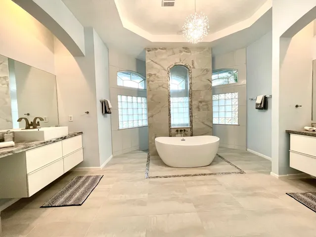 a spacious bathroom with a granite countertop sink and a mirror