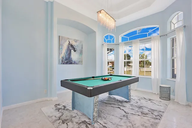 a room with pool table and windows