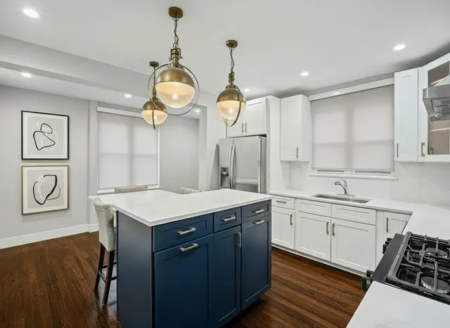 a kitchen with a sink dishwasher a dining table and chairs with wooden floor