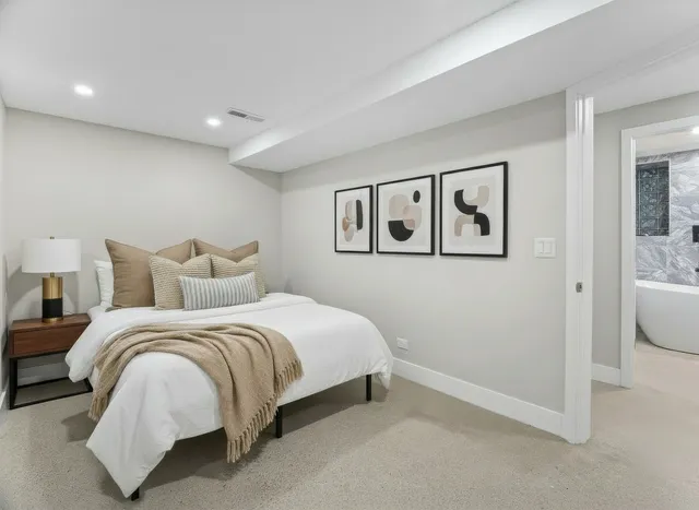 a bedroom with a bed and painting on the wall