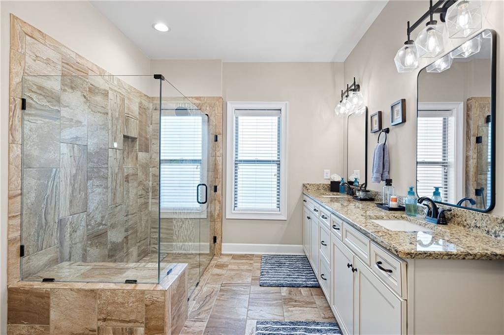 102 Kirk Drive Dallas, GA 30132 - Photo 17 of 28 a bathroom with a granite countertop double vanity sink mirror bathtub and shower