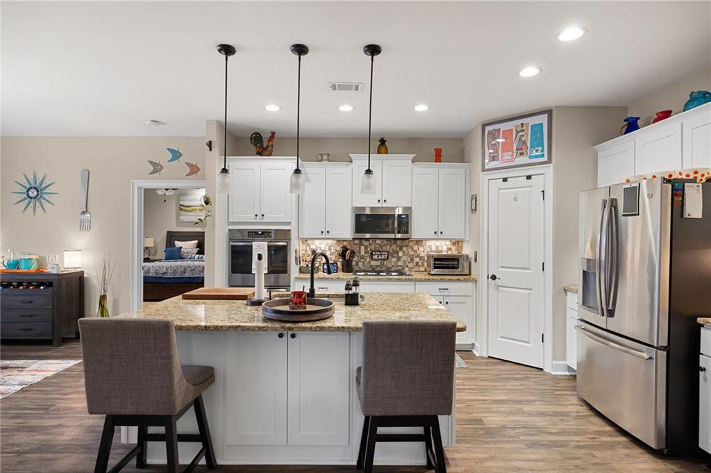102 Kirk Drive Dallas, GA 30132 - Photo 8 of 28 a kitchen with stainless steel appliances granite countertop a refrigerator a oven a sink a stove and a dining table with wooden floor
