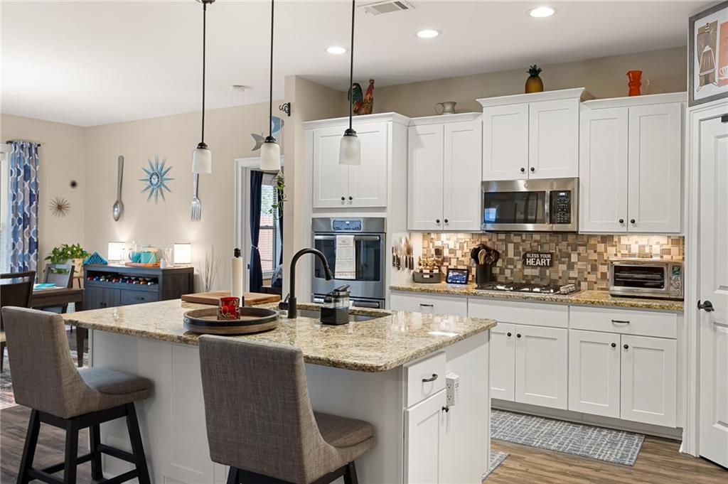 102 Kirk Drive Dallas, GA 30132 - Photo 10 of 28 a kitchen with kitchen island granite countertop a stove a sink a center island and cabinets