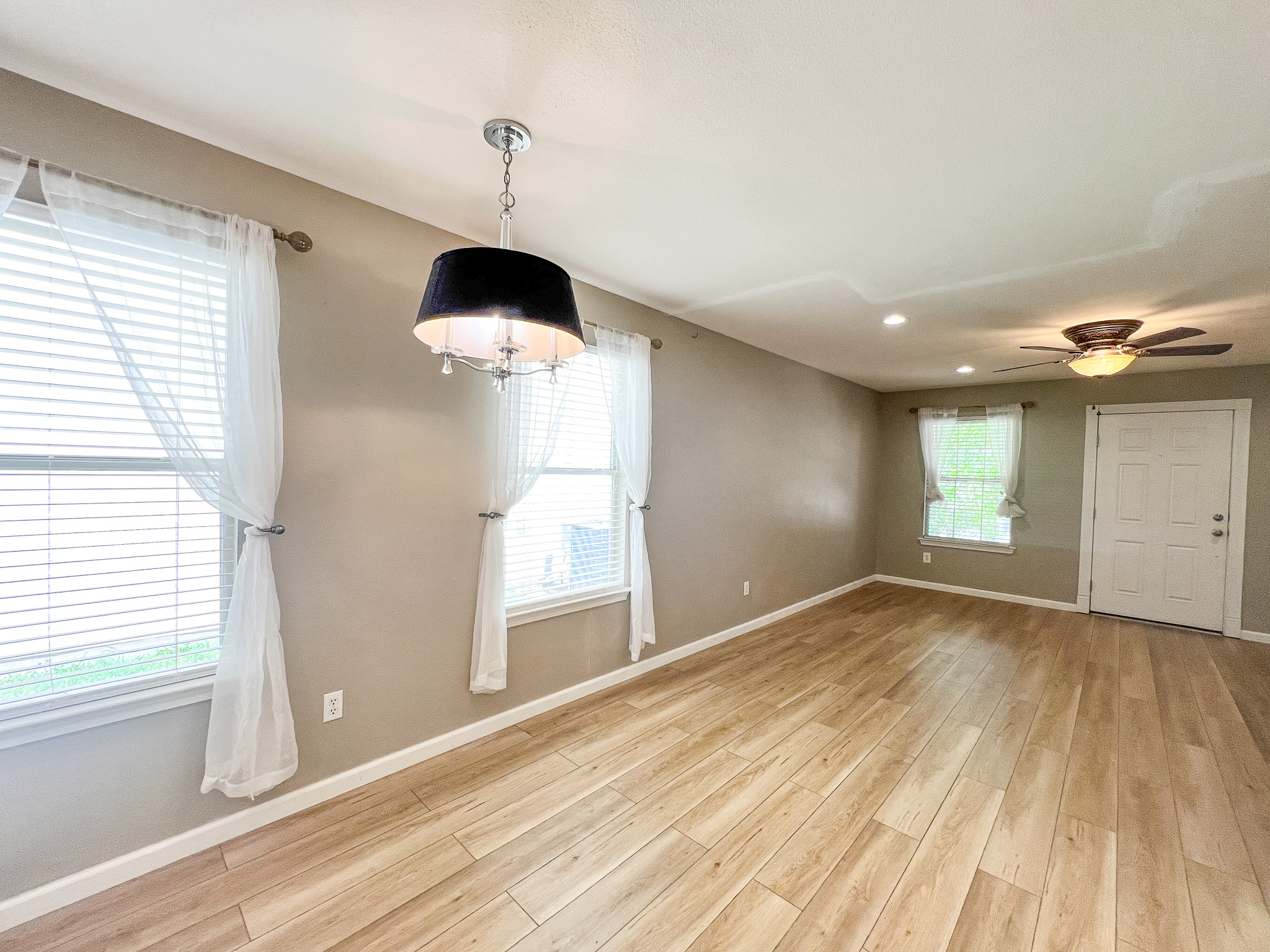 298 Jack Rabbit Lane Buda, TX 78610 - Photo 16 of 24 Natural light cascades across the durable wood-look flooring, creating an inviting atmosphere.