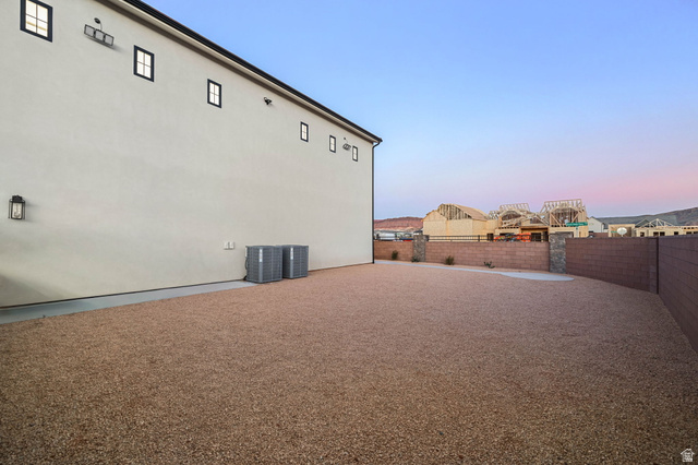 4871 South Homestead Way Washington, UT 84780 - Photo 120 of 151 Property exterior at dusk featuring a fenced backyard and stucco siding