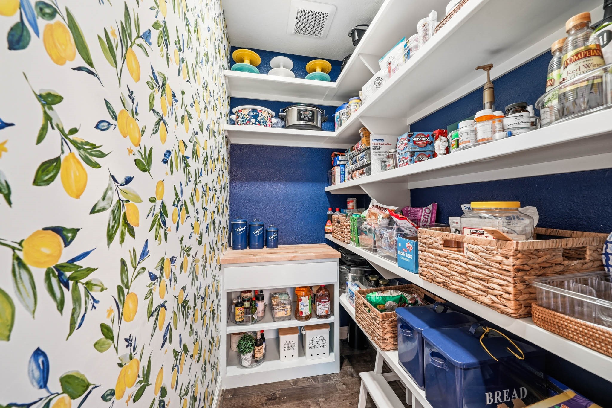 17610 Strackfield Lane Tomball, TX 77377 - Photo 16 of 50 The expansive pantry with bright and cheery wallpaper combines practicality with luxury, offering abundant storage that keeps everything organized and effortlessly accessible.
