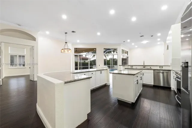 a kitchen with granite countertop white cabinets and white appliances