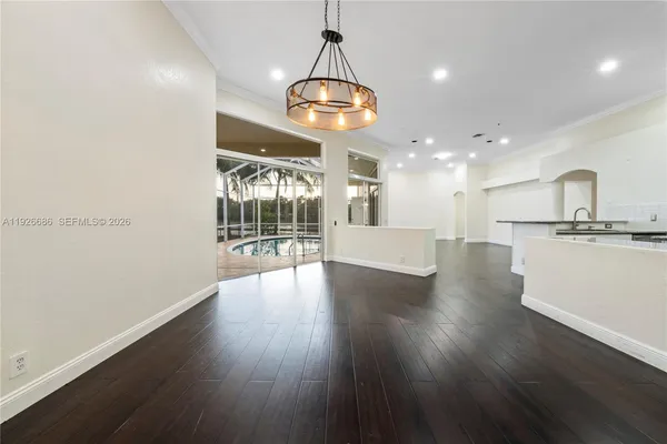 a view of a big room with wooden floor and a chandelier