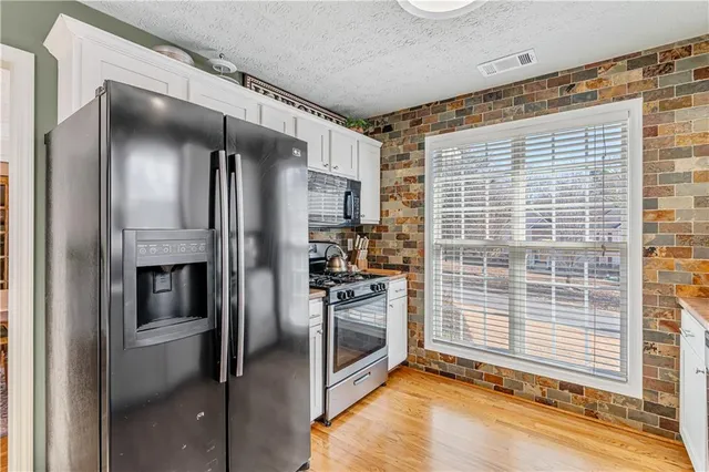 a kitchen with stainless steel appliances granite countertop a sink and cabinets