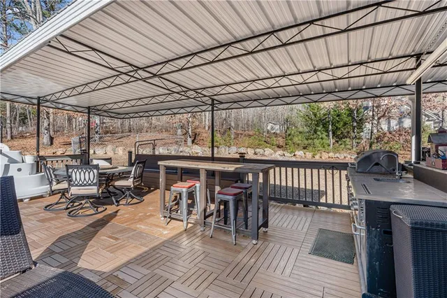 a view of a patio with chairs and floor to ceiling window next to a yard