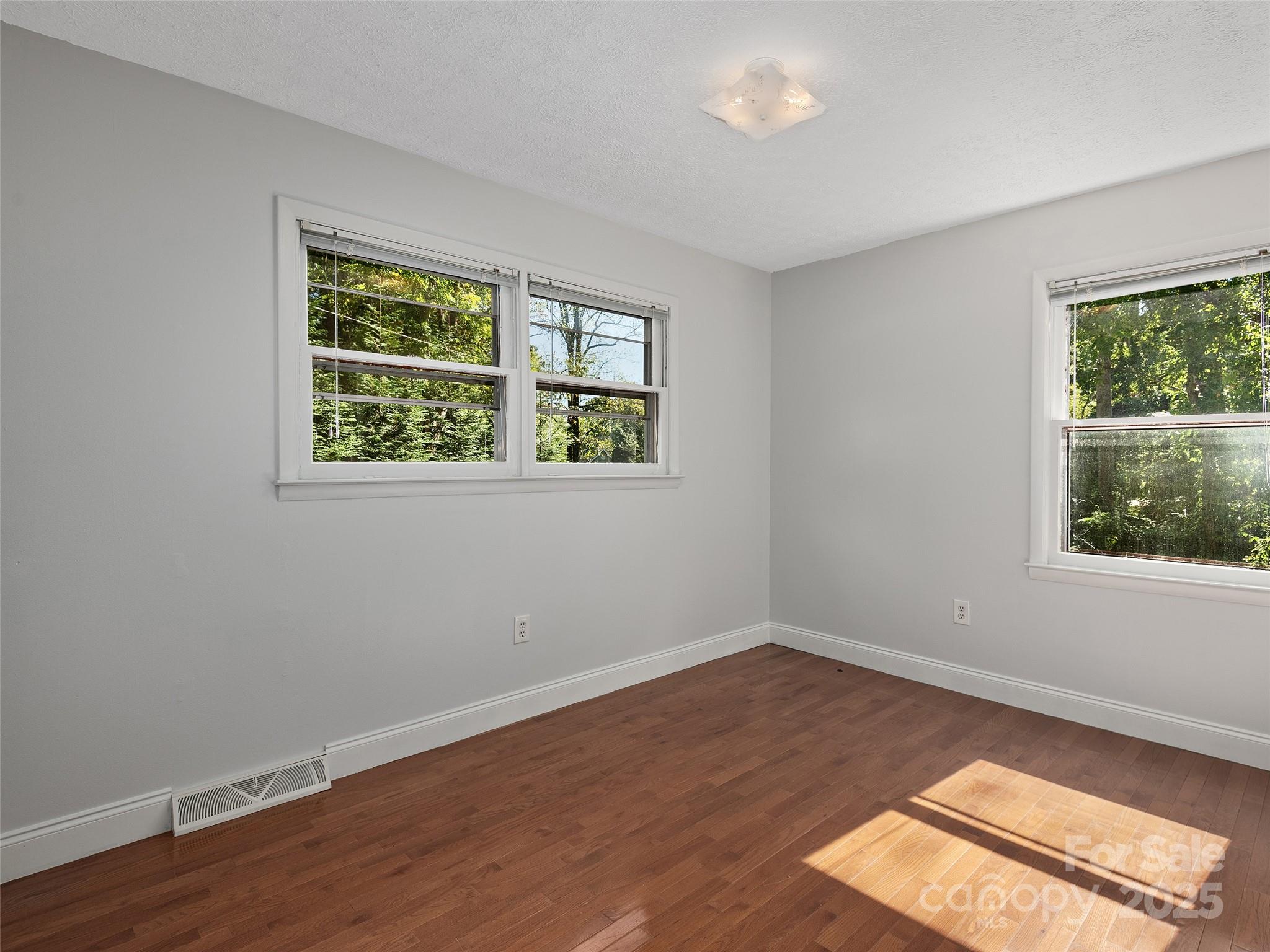 260 Old Haw Creek Road Asheville, NC 28805 - Photo 8 of 15 a view of an empty room with wooden floor and a window
