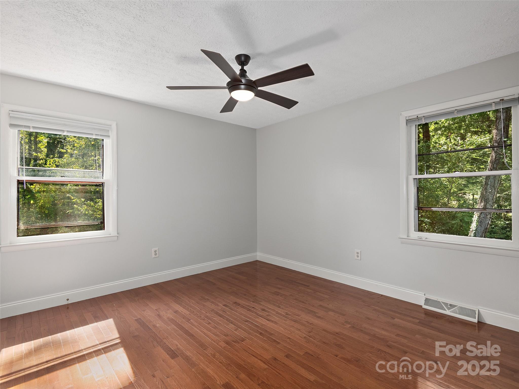 260 Old Haw Creek Road Asheville, NC 28805 - Photo 10 of 15 a view of an empty room with wooden floor and a window