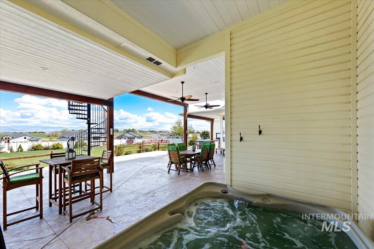 414 East Shafer View Drive Meridian, ID 83642 - Photo 20 of 50 Covered 60x33 back patio featuring an outdoor Jacuzzi Hot Tub/Spa off the Primary Bdrm, stamped concrete flooring, 2 ceiling fans, Outdoor lighting, Outdoor Kitchen and a spiral staircase