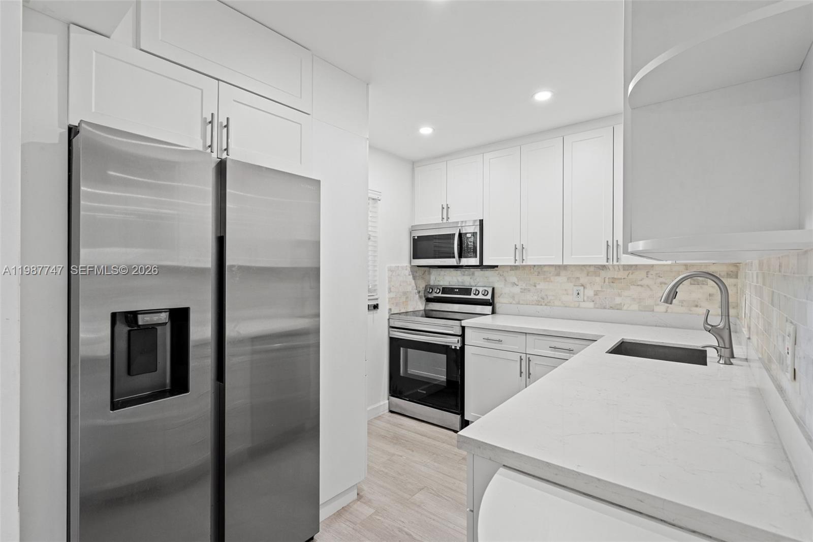 7765 Southwest 86th Street, Unit F2303 Miami, FL 33143 - Photo 12 of 50 a kitchen with stainless steel appliances granite countertop a refrigerator sink and stove