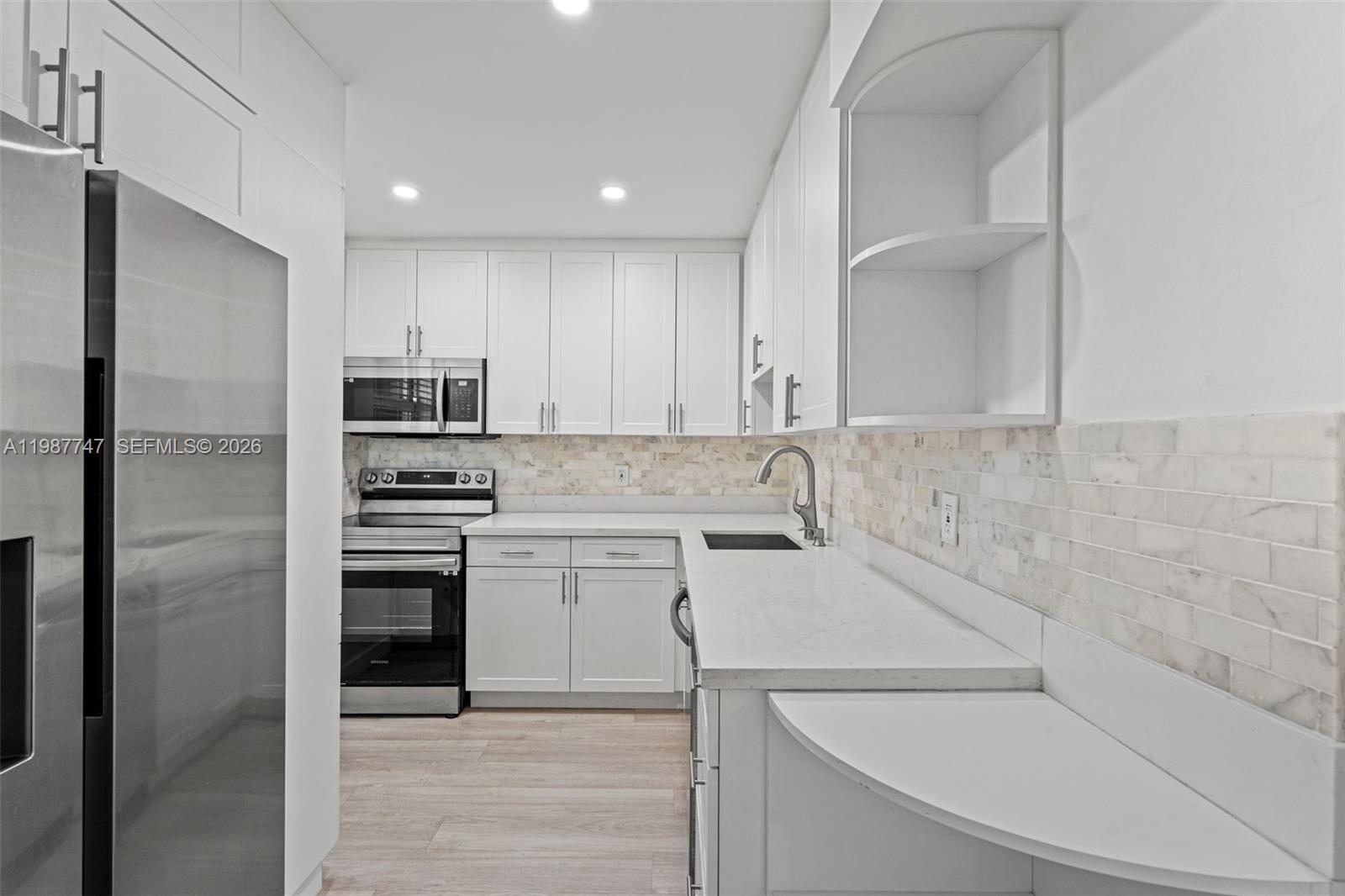 7765 Southwest 86th Street, Unit F2303 Miami, FL 33143 - Photo 13 of 50 a kitchen with a sink cabinets and stainless steel appliances