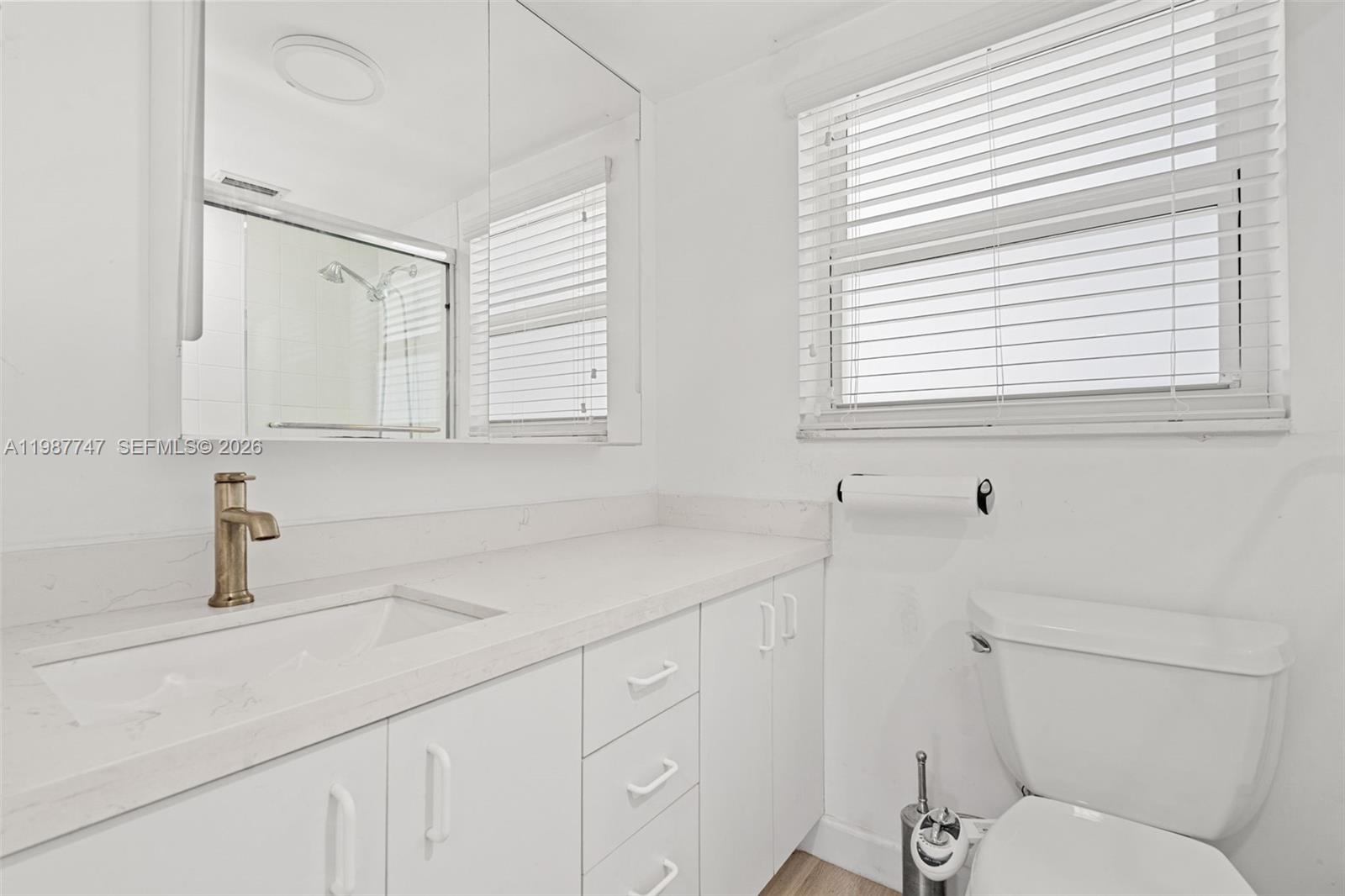 7765 Southwest 86th Street, Unit F2303 Miami, FL 33143 - Photo 23 of 50 a bathroom with a sink a toilet and a window
