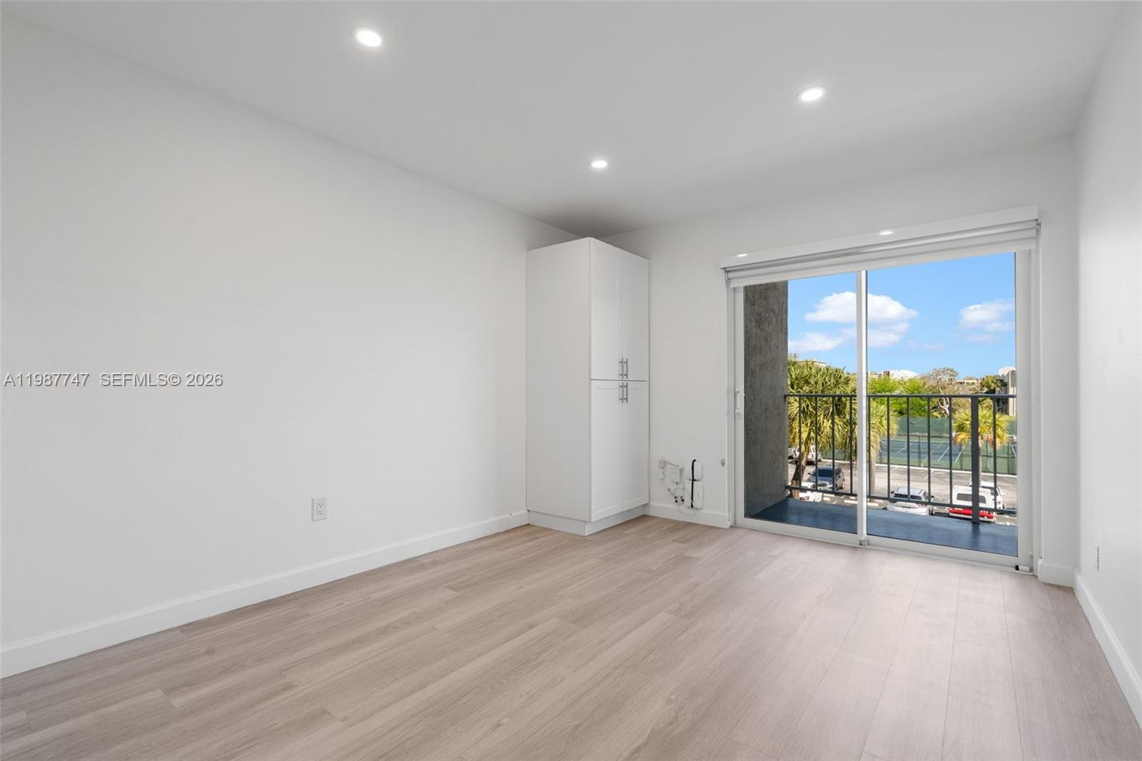 7765 Southwest 86th Street, Unit F2303 Miami, FL 33143 - Photo 27 of 50 an empty room with wooden floor and windows